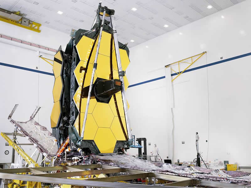 The fully assembled James Webb Space Telescope with its sunshield and unitized pallet structures (UPSs) that fold up around the telescope for launch, are seen partially deployed to an open configuration to enable telescope installation.