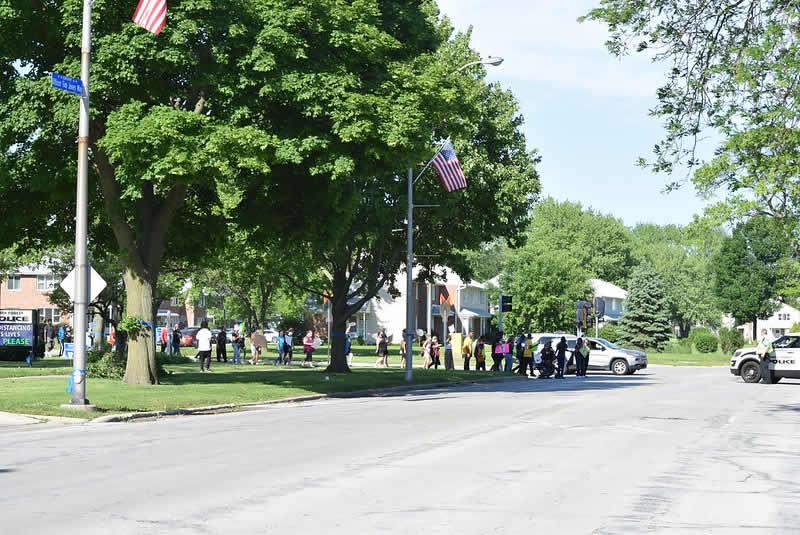 Protesters cross at Lakewood Blvd. and Forest Blvd. on June 12 aided by police.