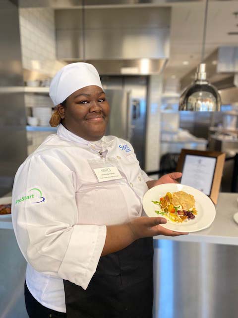 young woman in chfs outfit holding plate