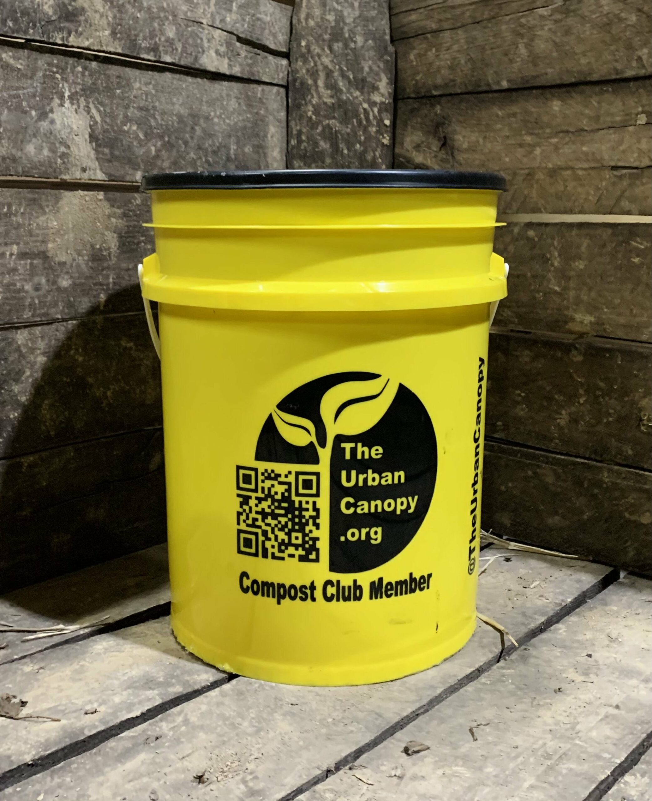 yellow plastic bucket with black lid