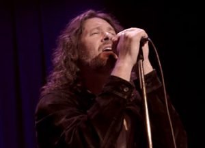 Man singing with both hands holding microphone