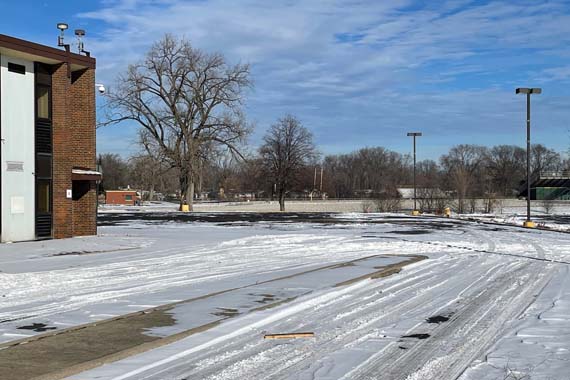 snow covered parking lot with building to the left