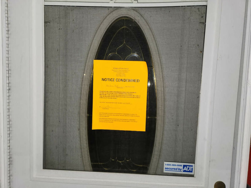 The notice on the door of the front door marking the home as condemned.