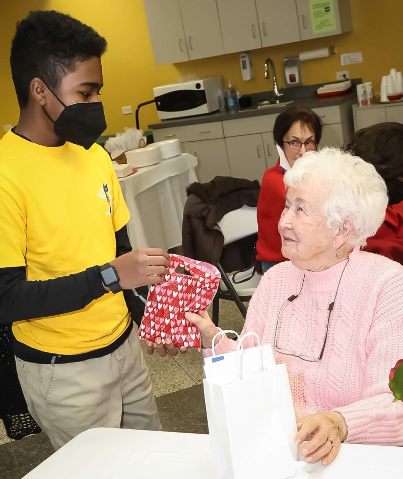 Charles Mackel, an eighth grader at Huth Middle School in Matteson, gives a Valentine’s Day card to Charlotte Kowalsky, 97, of Crete.