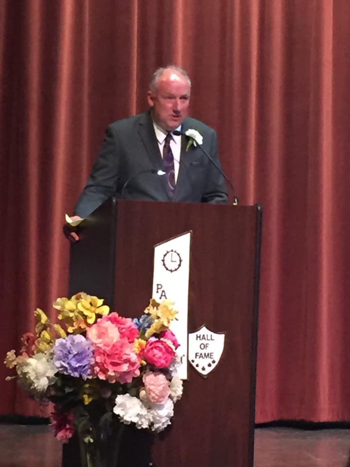 Man in suit delivering speech from behind podium