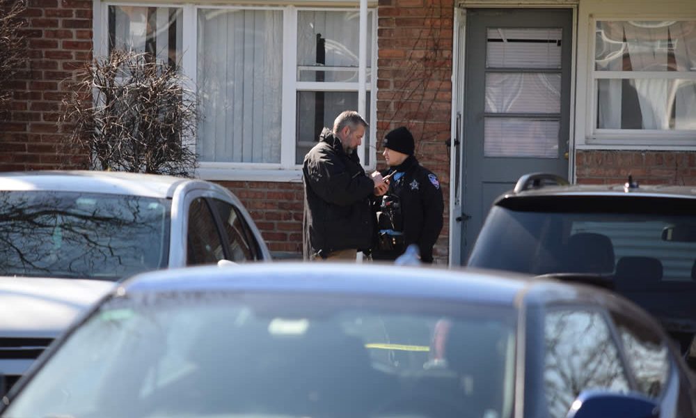 Officers confer before an apartment where the shootings appeared to have occurred. (Photo: Gary Kopycinski