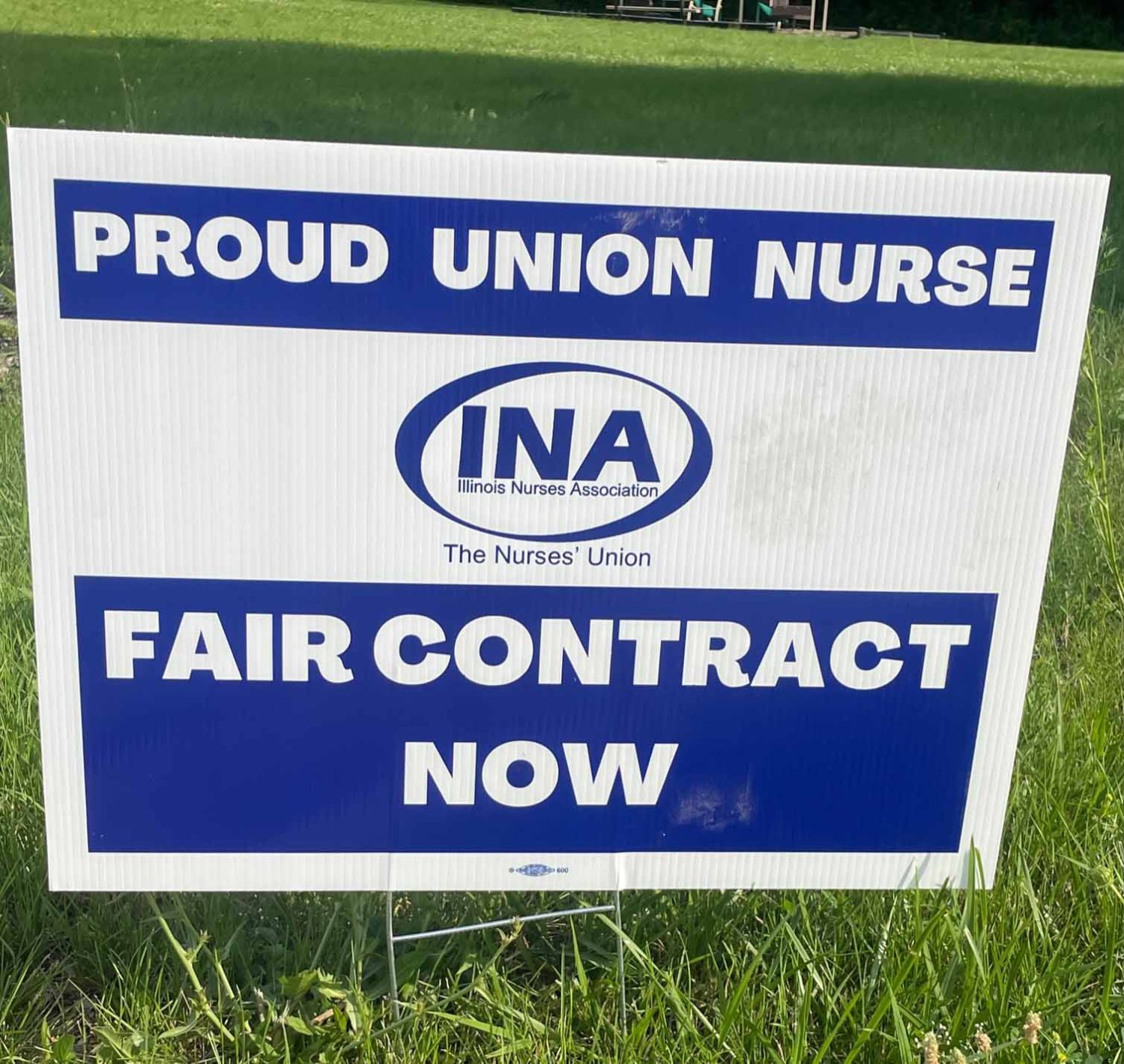 white sign with blue lettering asking for a new contract