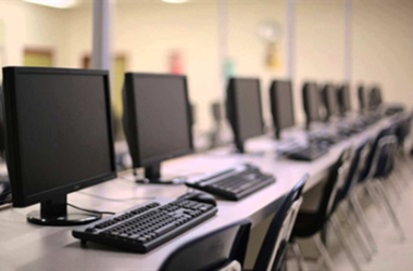 long table with computer monitors and keyboards