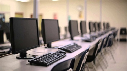 long table with computer monitors and keyboards