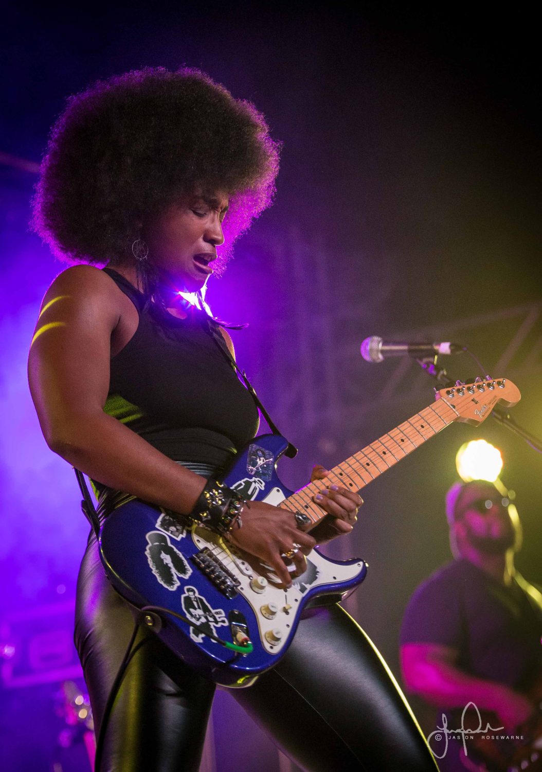woman on stage playing electric guitar