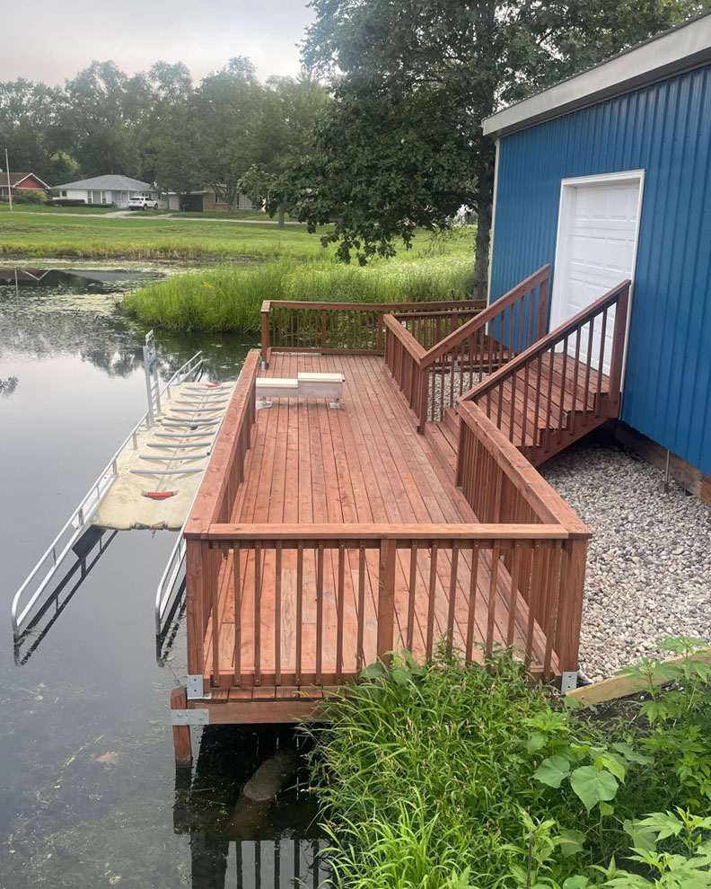 a wooden boat launch adjacent to a pond