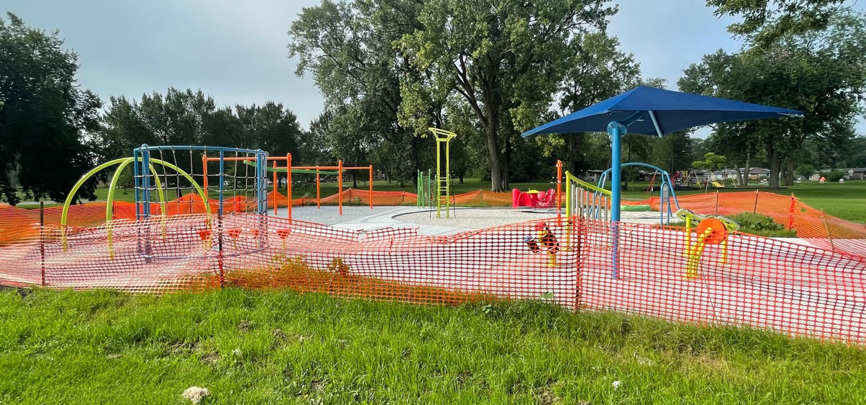 playground equipment surround by orange plastic fencing