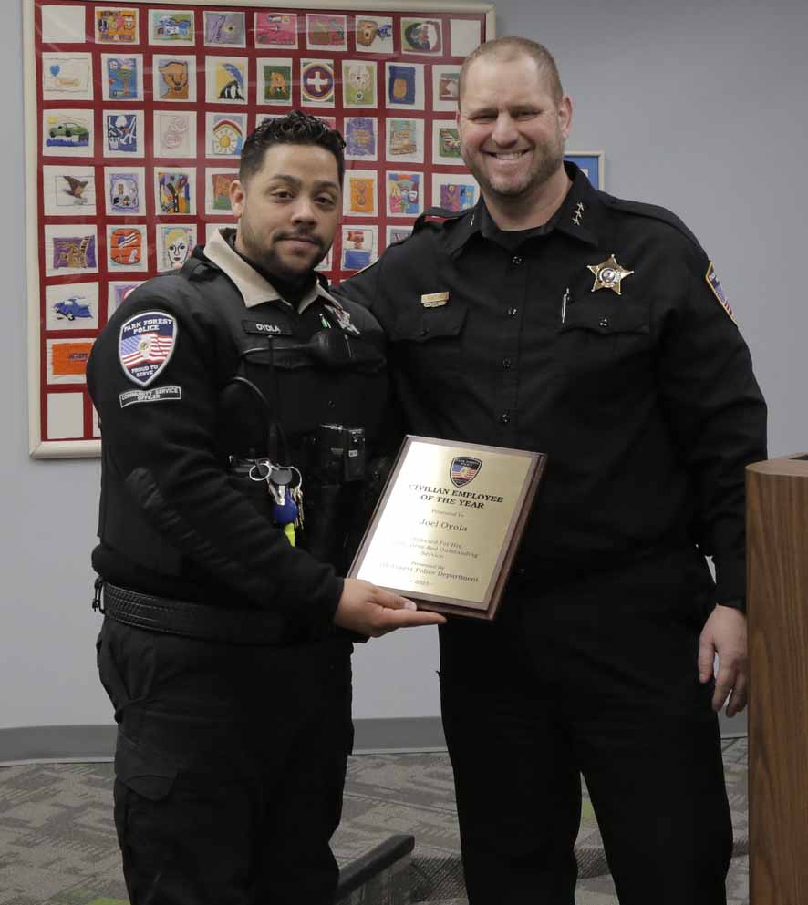 two officers in uniform with one holding a plaque