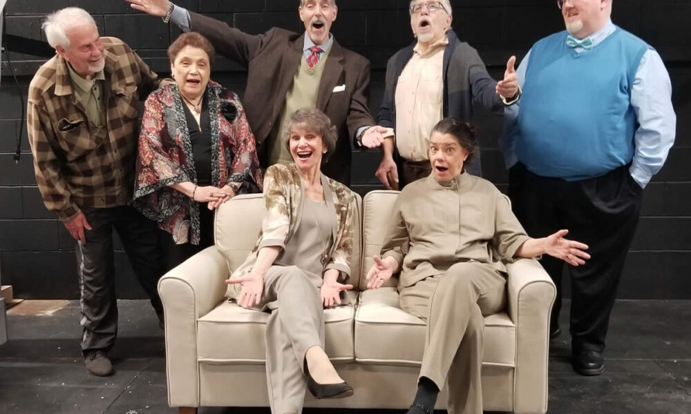 (L to R) Tim (Tim Bray), Ann (Rose Crockett), Reggie (Mike Cabsinger), Wilf (Ken Hawkley) and Bobby (Michael Behrens) stand behind Jean (Liliana Mitchell) and Cissy (Alicia Cuccia) in this cast photo. The comedy Quartet runs at The Drama Group from April 12 to 21.