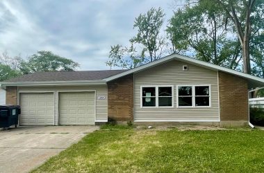 house with two-car attached garage and a dumpster next to the garage