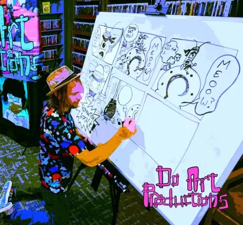 man sitting at a large easel drawing comic books