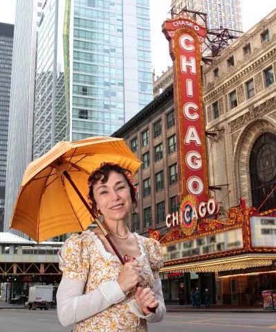 woman holding an umbrella standing in front of a theater
